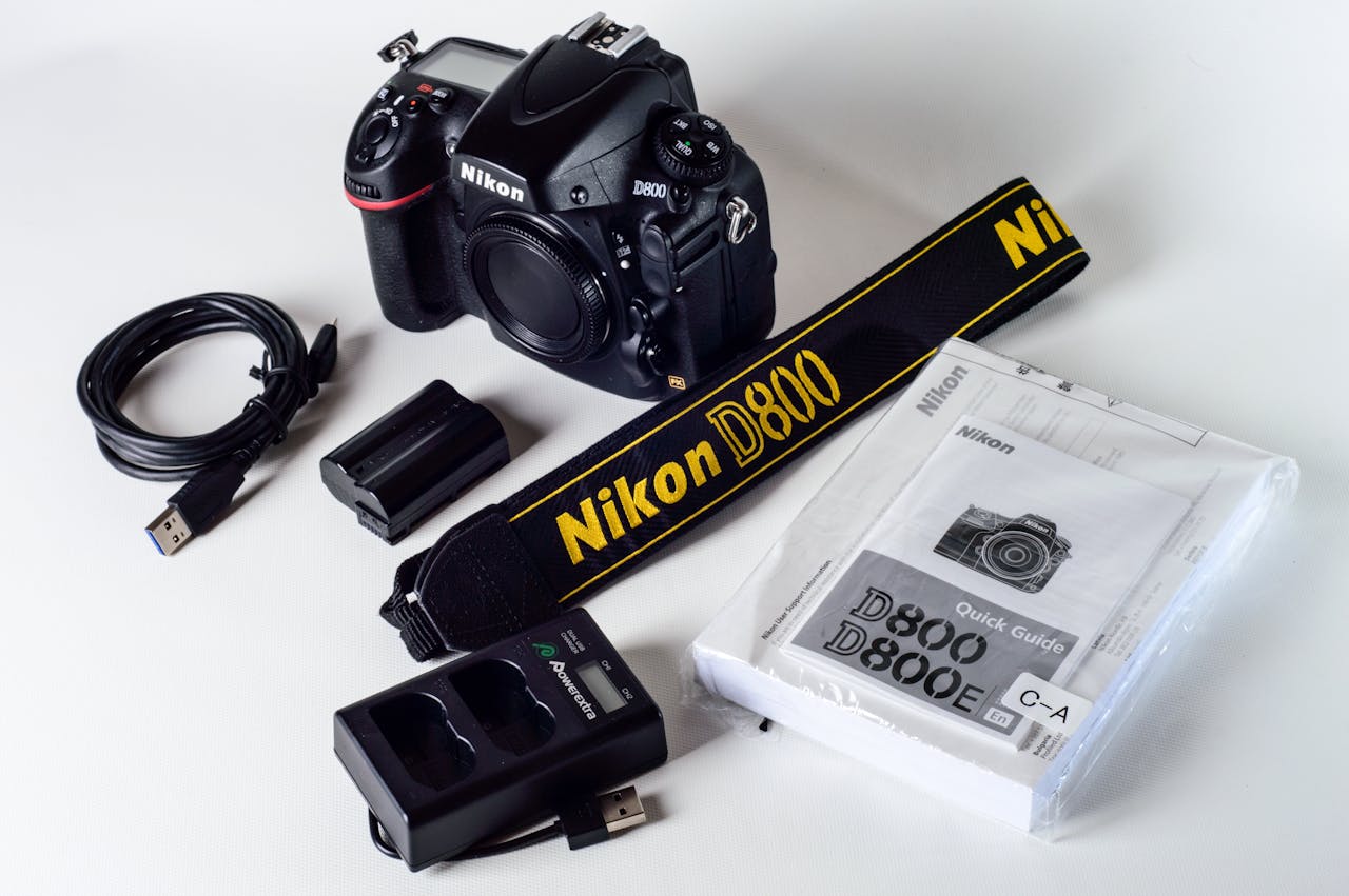Nikon D800 camera setup with strap, USB cable, charger, and manual on a white background.